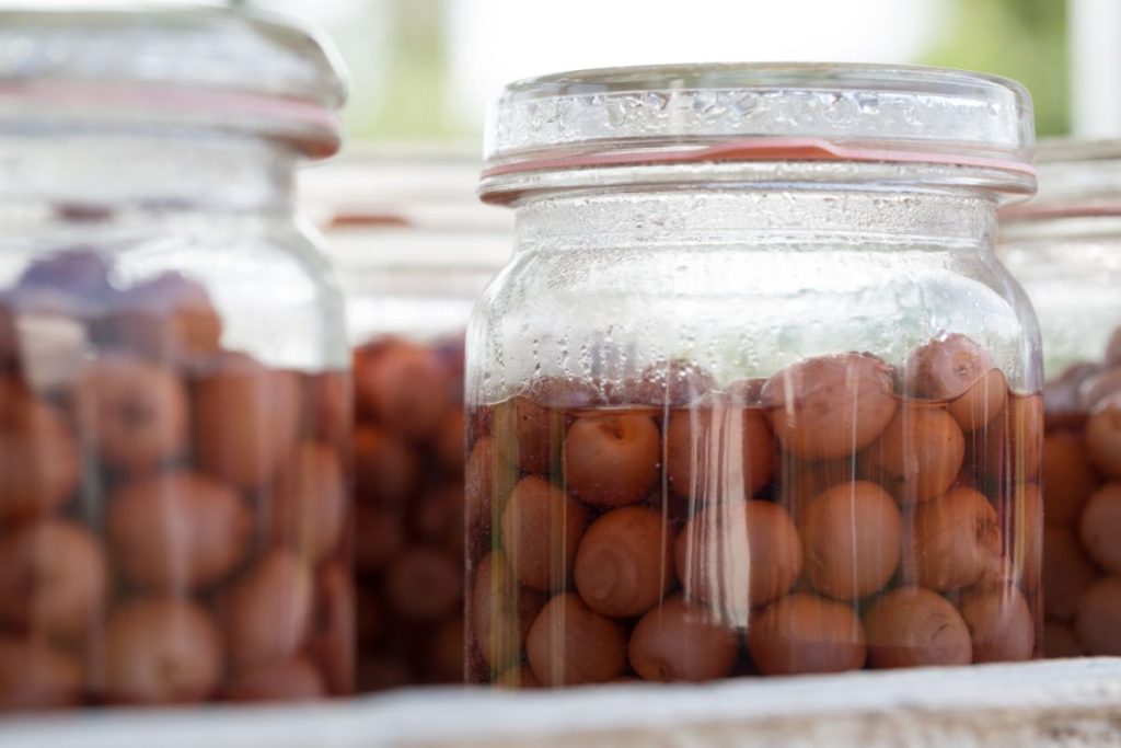 Close up jars of cherries that have been stored and lost color