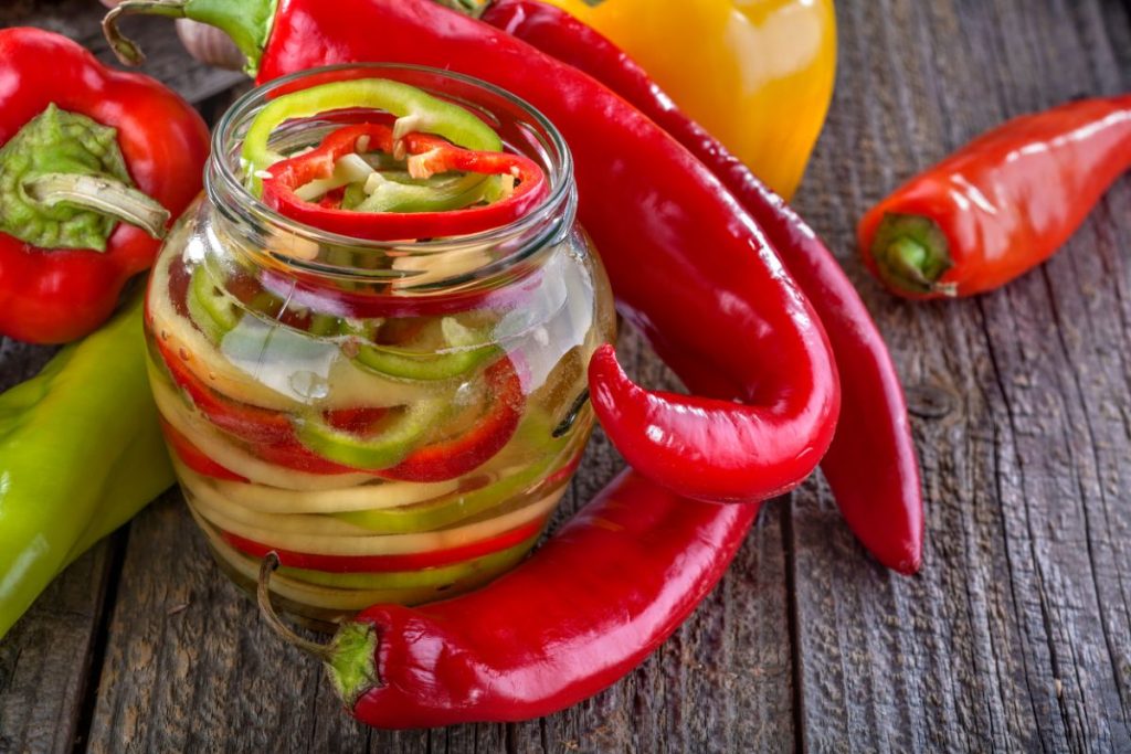 Jar of green yellow and red pickled bell peppers