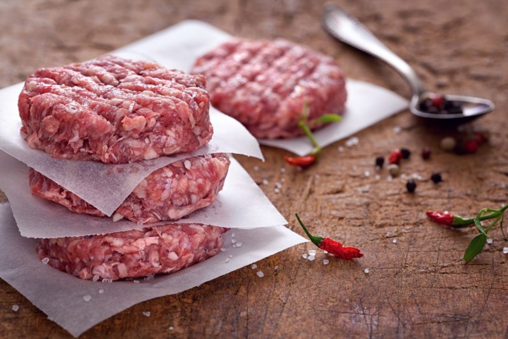 Small, raw beef patties that are 2 inches in diameter