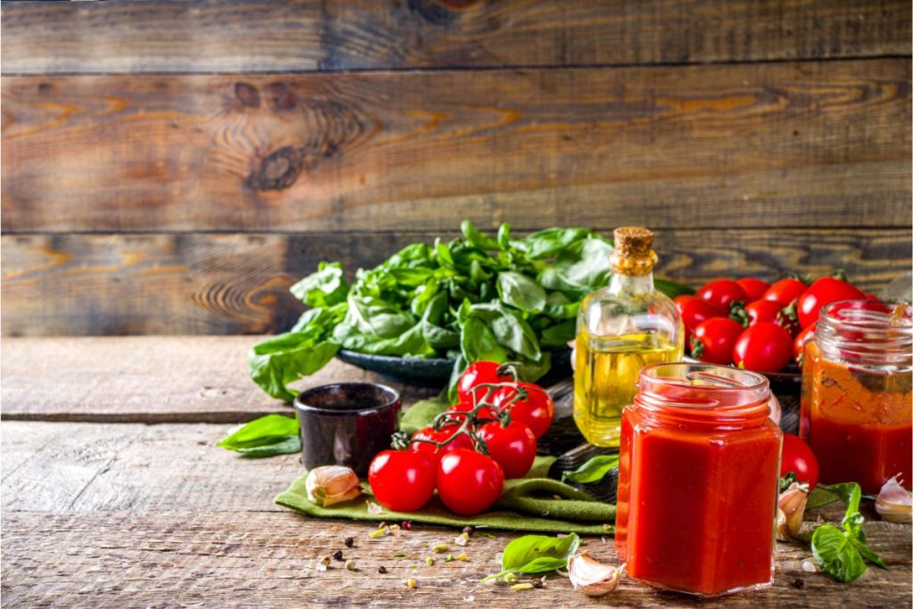 Table with tomatoes, basil, olive oil, and garlic.