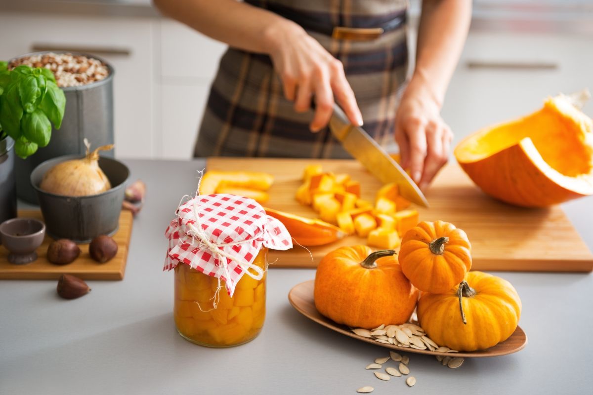 woman preparing canned pumpkin and slicing pumpkin into cubes