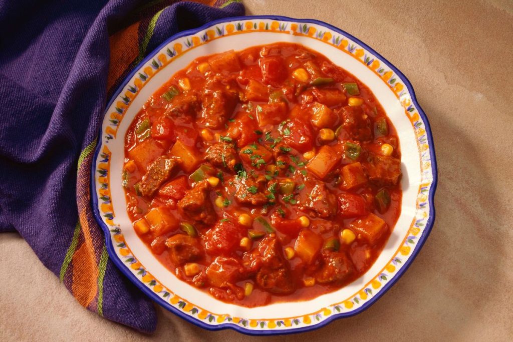 Stewed tomatoes and beef stew in a bowl