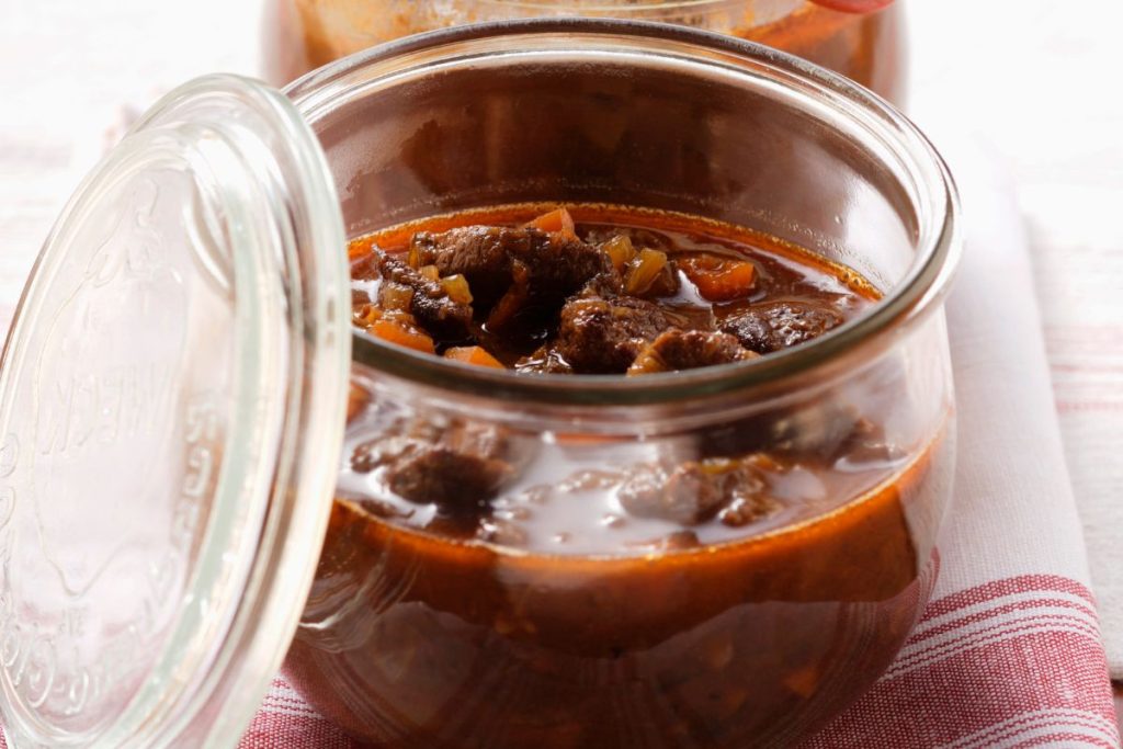 Cooked venison cubes in ragout inside canning jar