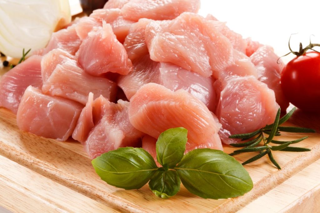 Diced raw turkey breast on cutting board