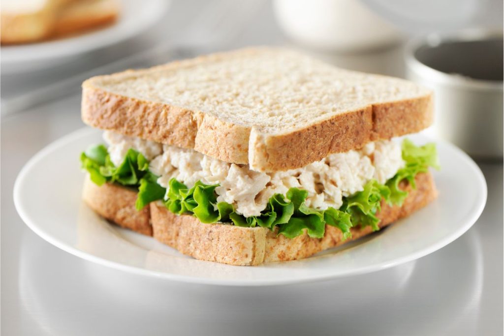 Tuna sandwich on white bread with lettuce
