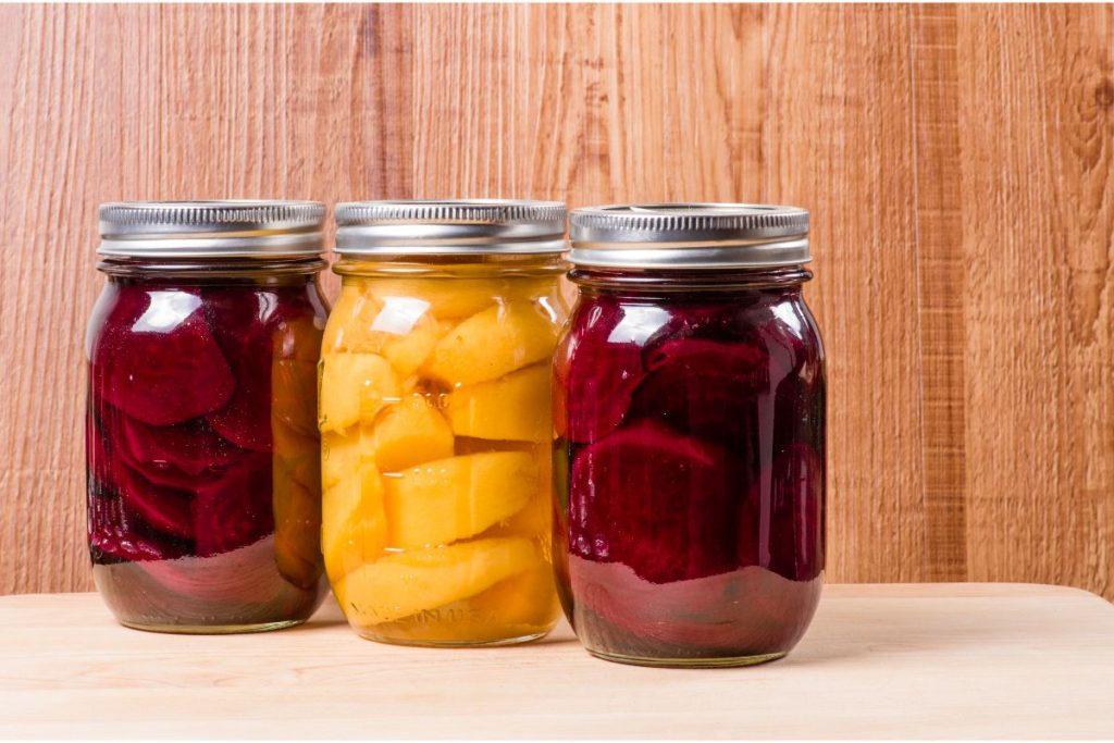Three mason jars of canned beets, including yellow and red beets