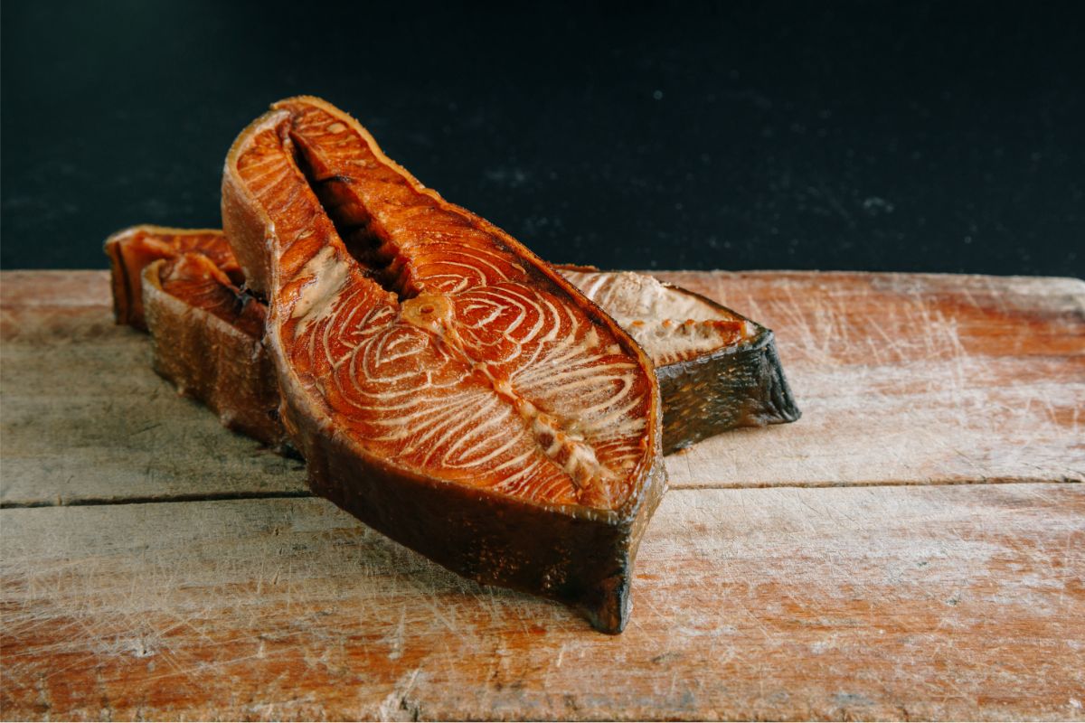 Red smoked salmon pieces on wooden surface