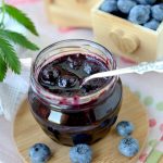 Blueberry jam with spoon and fresh berries