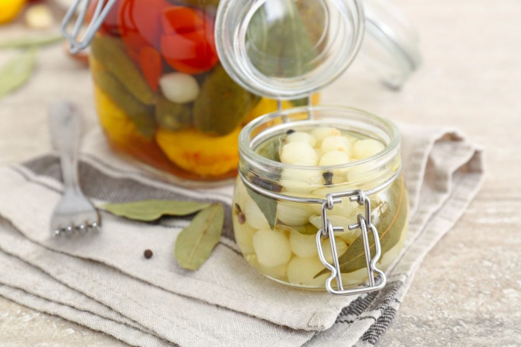Jar of pickled onions with bay leaves