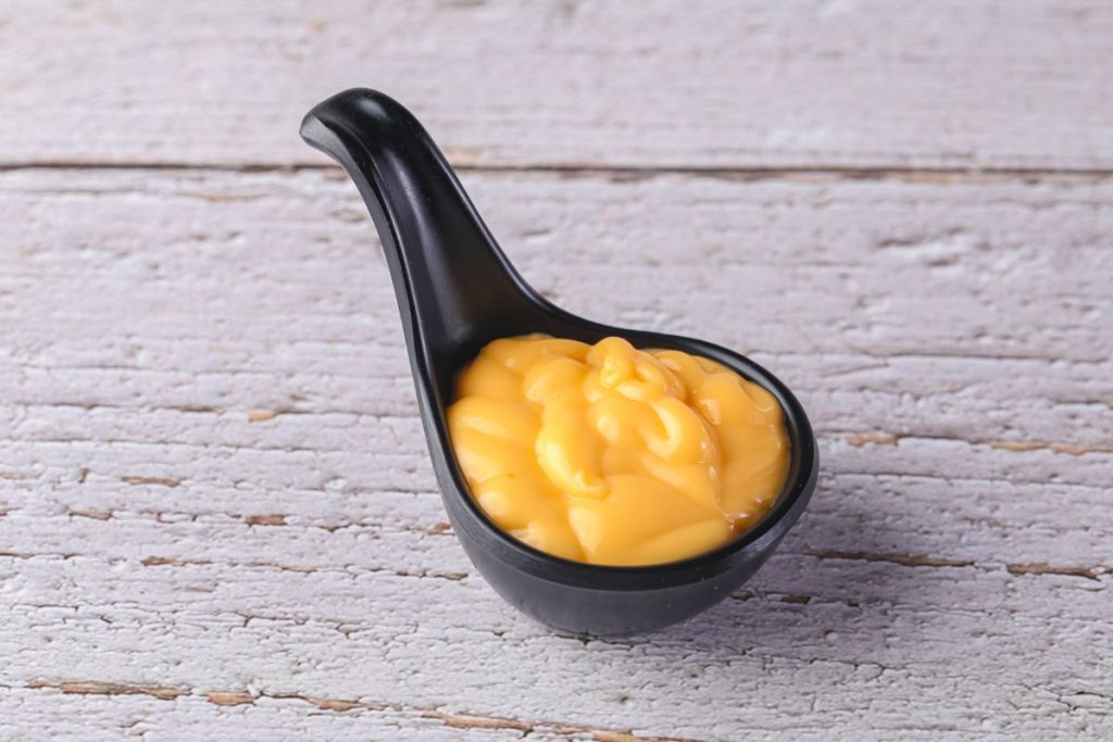 Soup spoon filled with cheese sauce