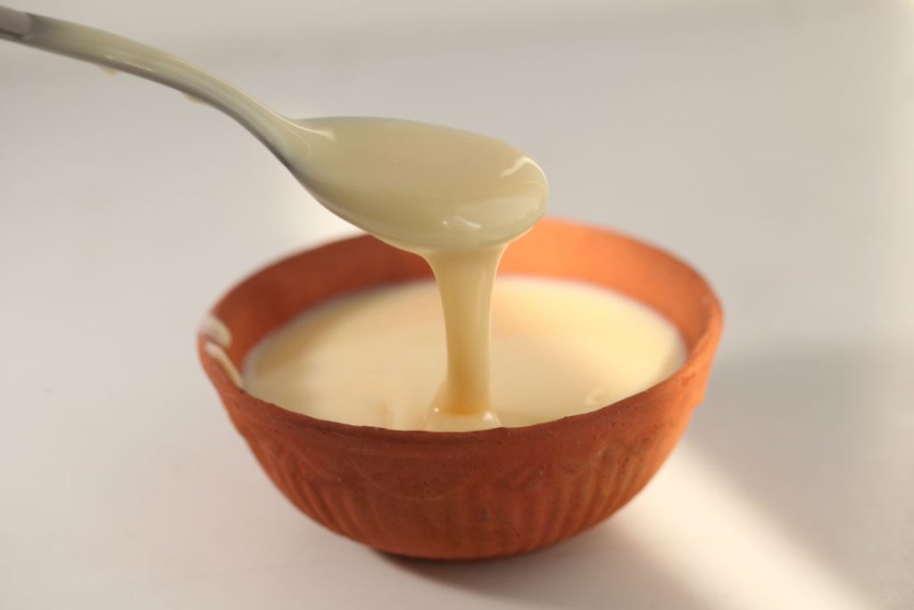 A bowl of sweetened condensed milk with a spoon