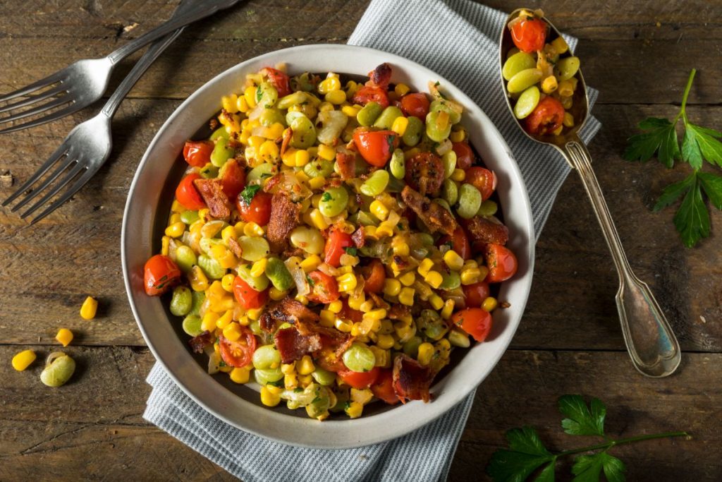 Butter bean and corn succotash in a plate with bacon