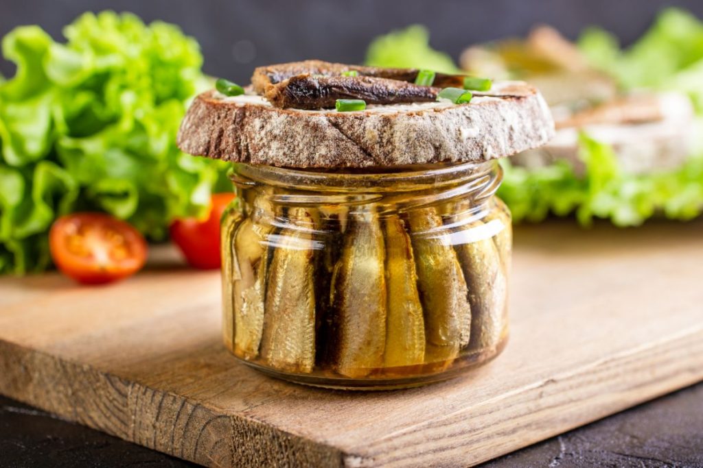 Canned fish in jar covered by a slice of bread