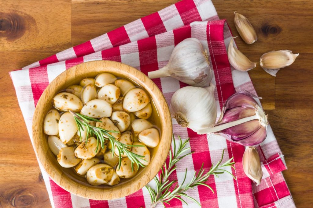 Bowl of preserved garlic in a bowl covered in oil