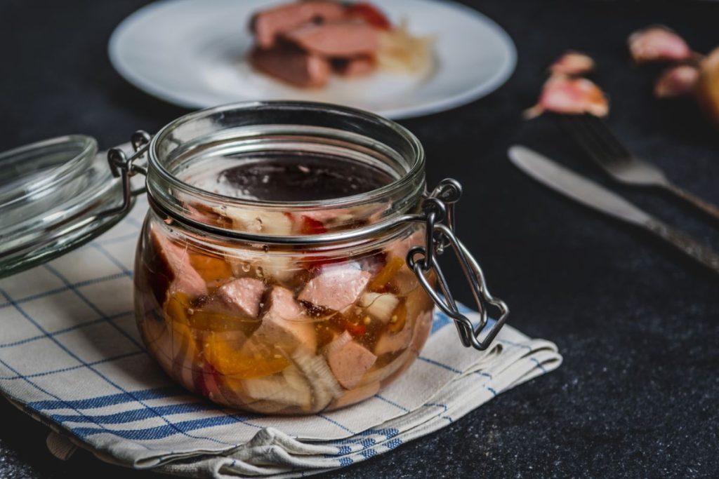 Canning jar with pickled pork sausage pieces