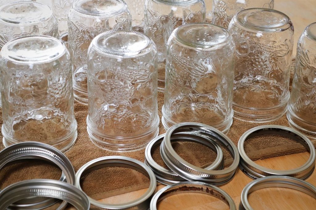 Several pint-sized canning jars upside down with screw bands