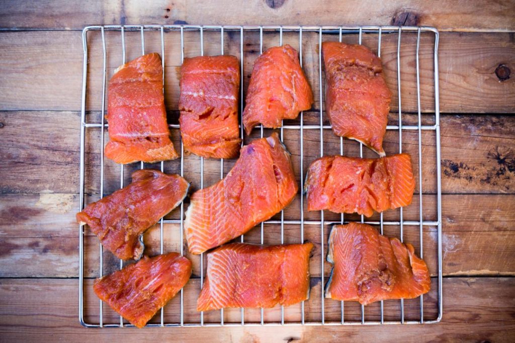 Smoked salmon filets on grate set on top of a wood surface