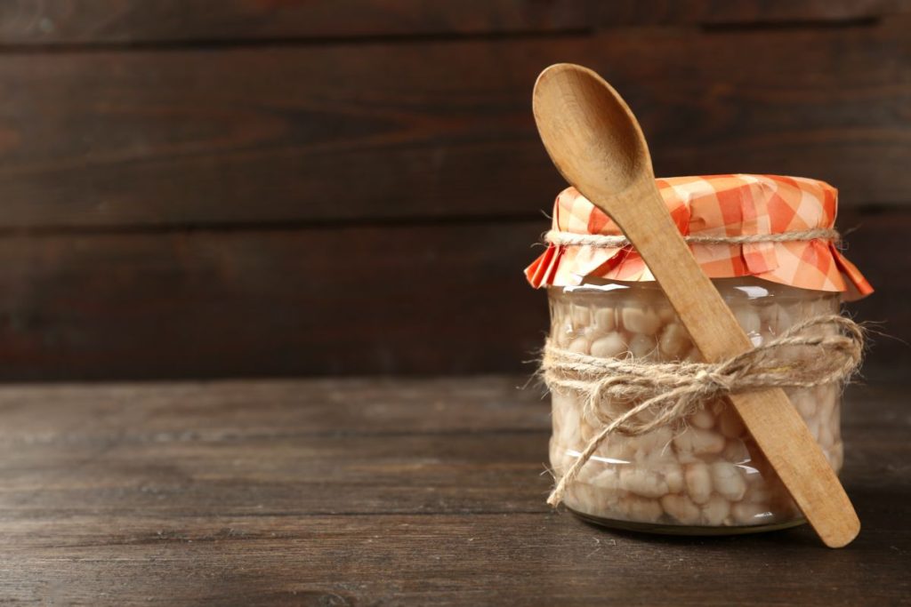 Jar of canned beans with a wooden spoon tied to the jar with twine