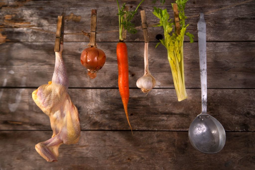 Ingredients for chicken soup hanging on a clothesline attached by clothespins