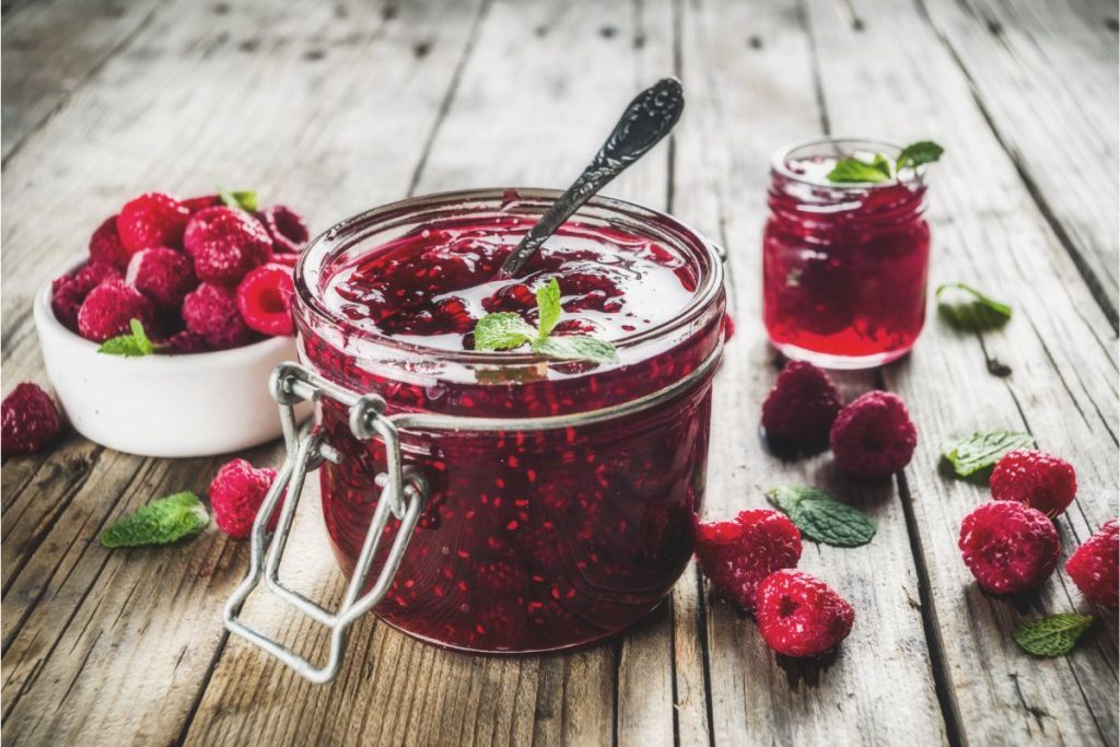 Raspberry jam jar with fresh raspberries