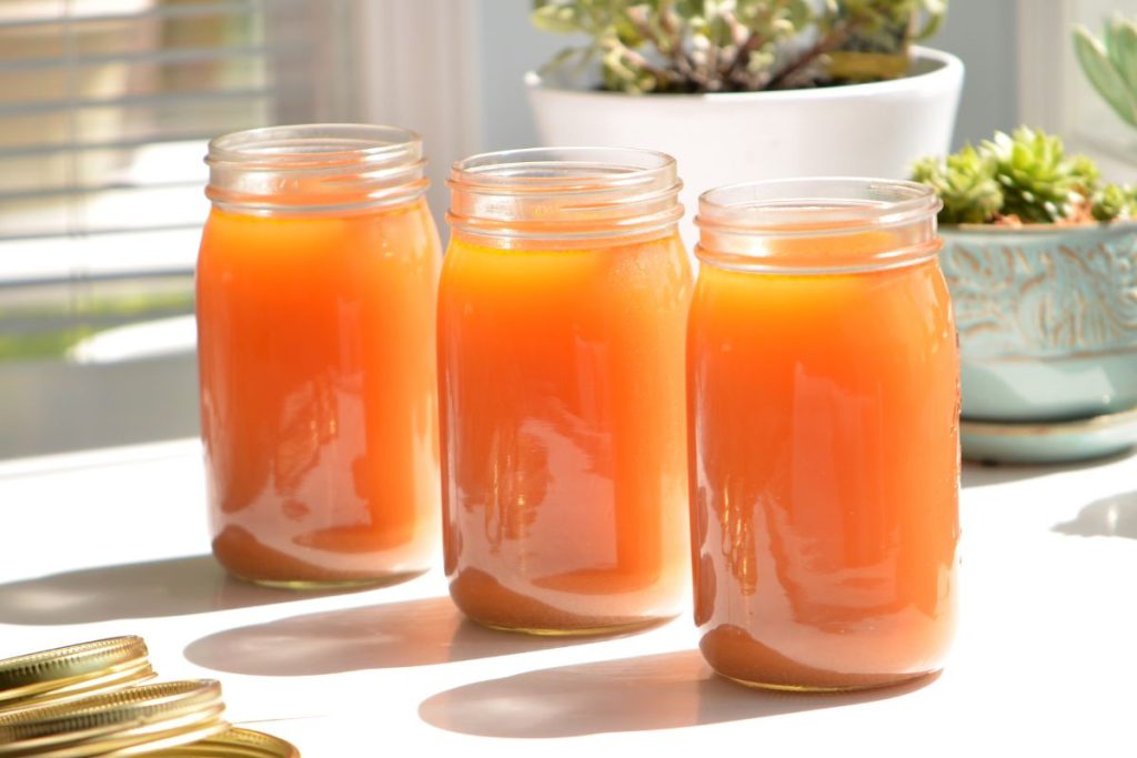 jars of vegetable broth on a countertop in the sun