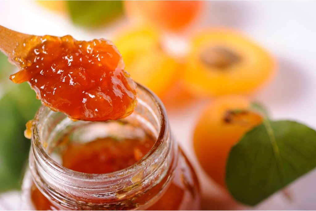 Up close photo of spoon full of apricot jam