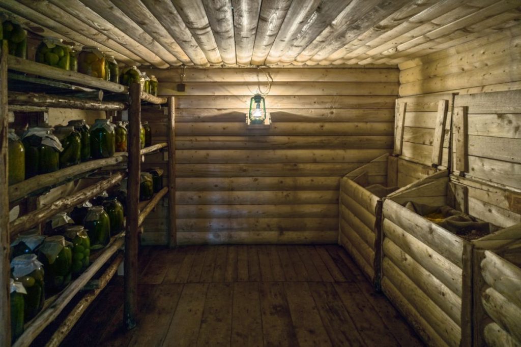 Homemade wood built basement with canned food storage shelves on one side and bins on the other side for dry food