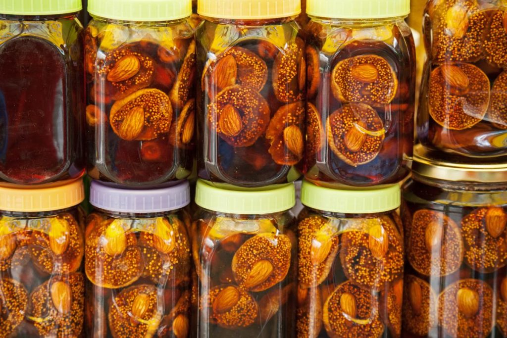 Canned figs with honey and almonds in storage, stacked two jars high