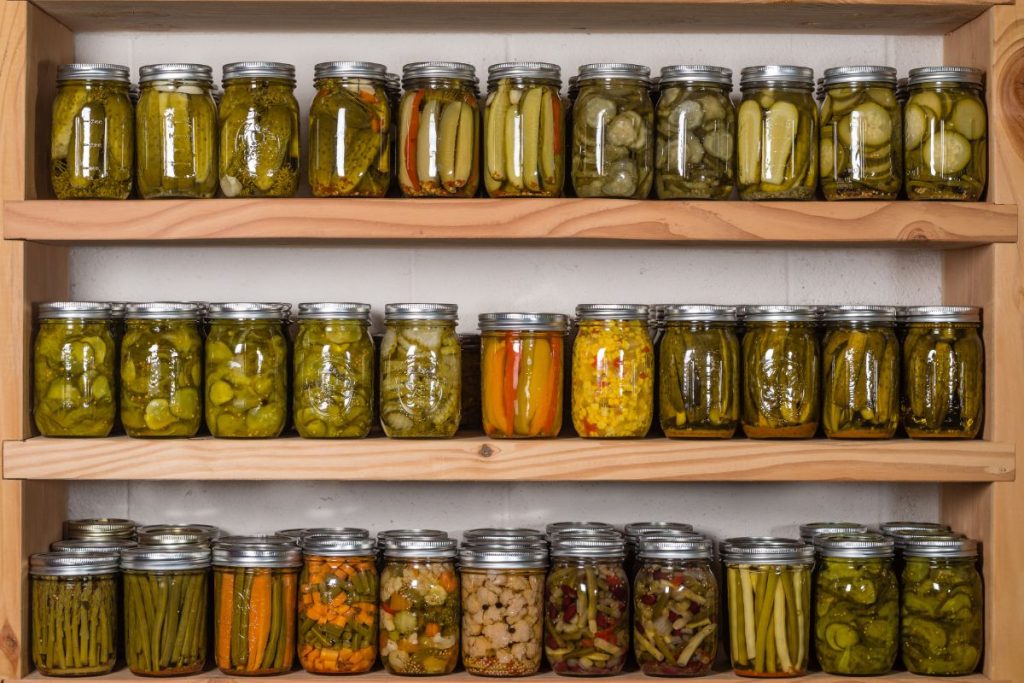 Hanging shelf for food storage filled with canned food jars