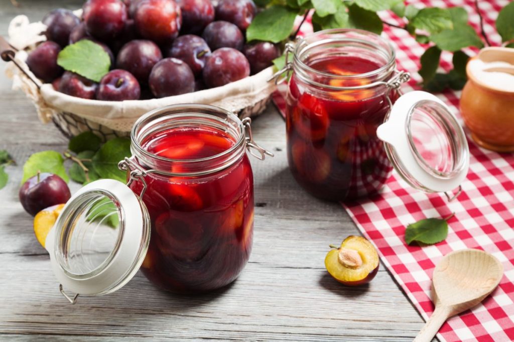 Two open jars of canned plums