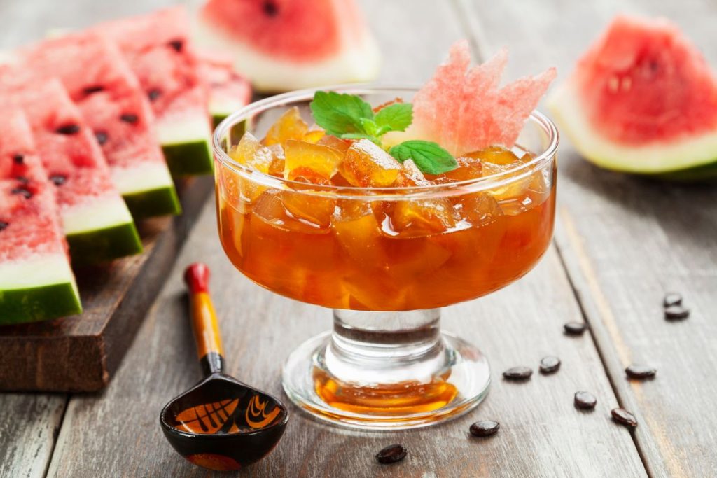 Watermelon jam in a dessert cup with freshly sliced watermelon