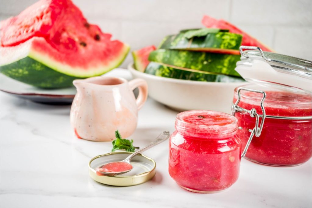 Watermelon jelly in canning jars with fresh watermelon